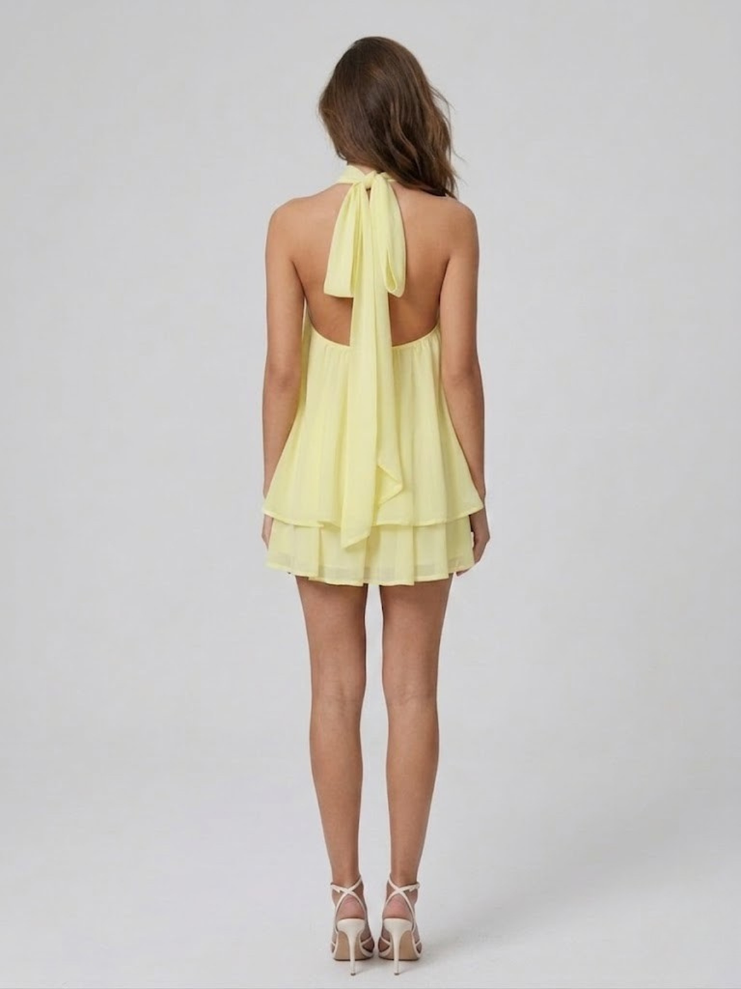 Vestito corto da donna con collo alto all'americana, schiena nuda e volant a balze