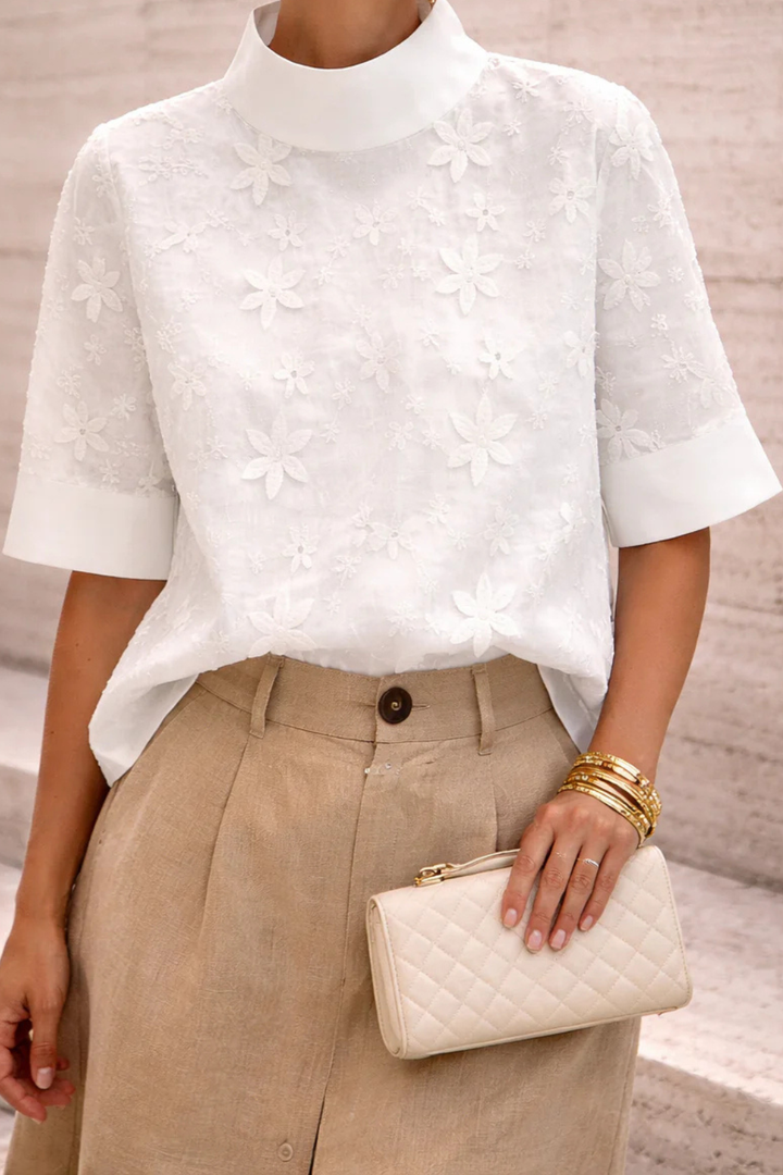 Blusa da donna bianca collo alto motivo floreale maniche corte