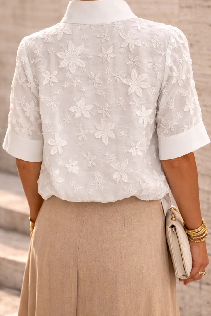 Blusa da donna bianca collo alto motivo floreale maniche corte