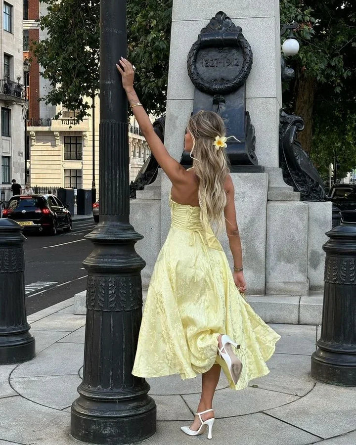 Abito midi donna giallo schiena nuda con gonna plissettata