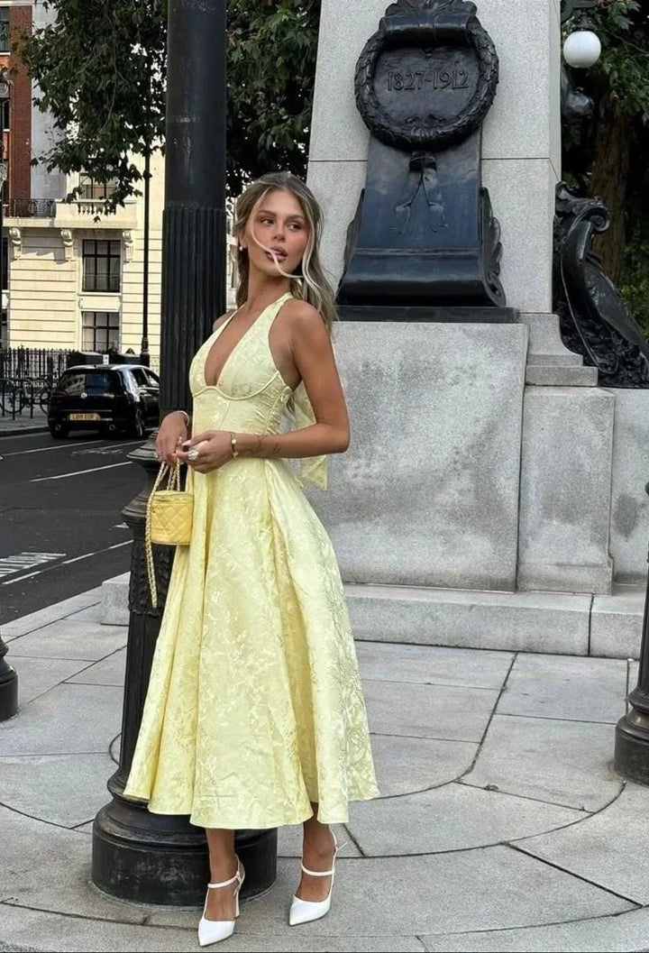 Abito midi donna giallo schiena nuda con gonna plissettata