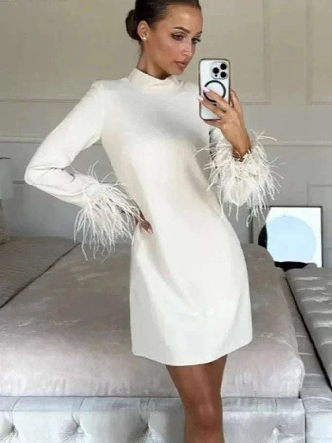 Vestito corto bianco con piume e maniche lunghe per la sera
