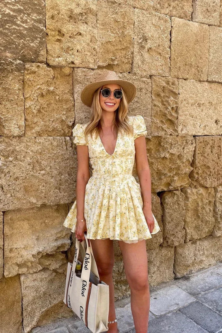 Vestito corto floreale giallo con schiena annodata per l'estate in giardino