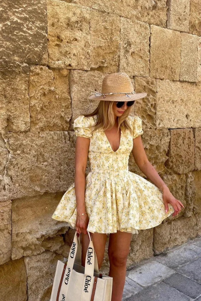 Vestito corto floreale giallo con schiena annodata per l'estate in giardino