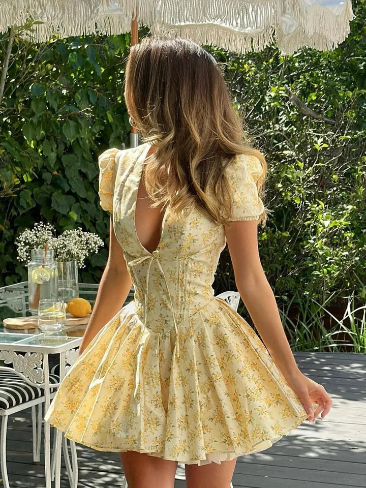 Vestito corto floreale giallo con schiena annodata per l'estate in giardino