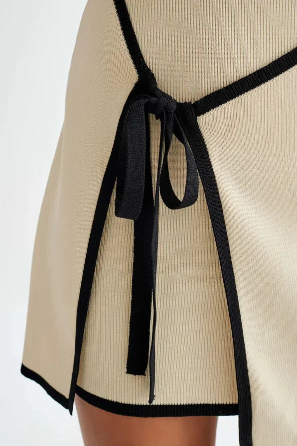 Vestito corto beige senza maniche bordi neri con fiocco